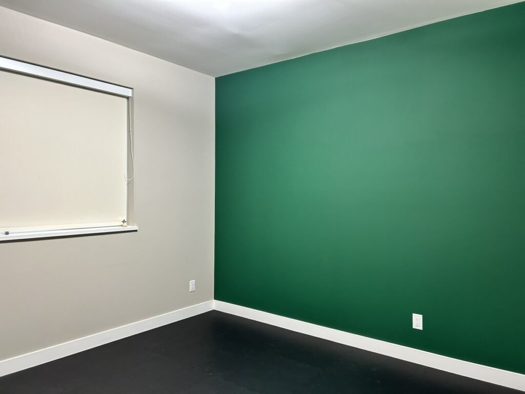 The current Filgap Coffee space in Squamish, with an empty room and a forest green wall.