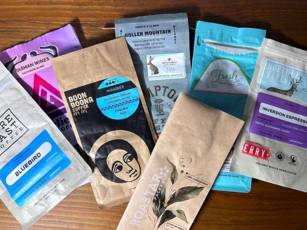Several coffee bags with different printed sample labels attached for packaging comparison.
