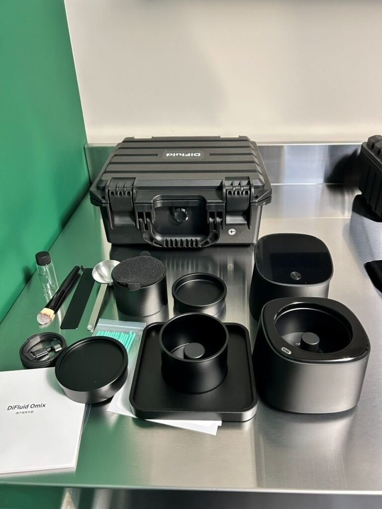 DiFluid Omix coffee analysis equipment and accessories arranged on a stainless worktable in the Filgap Coffee roasting room.