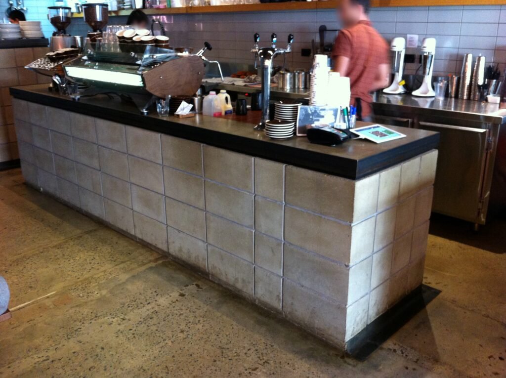 Espresso machine on a coffee bar built with visible concrete blockwork at Reuben Hills.