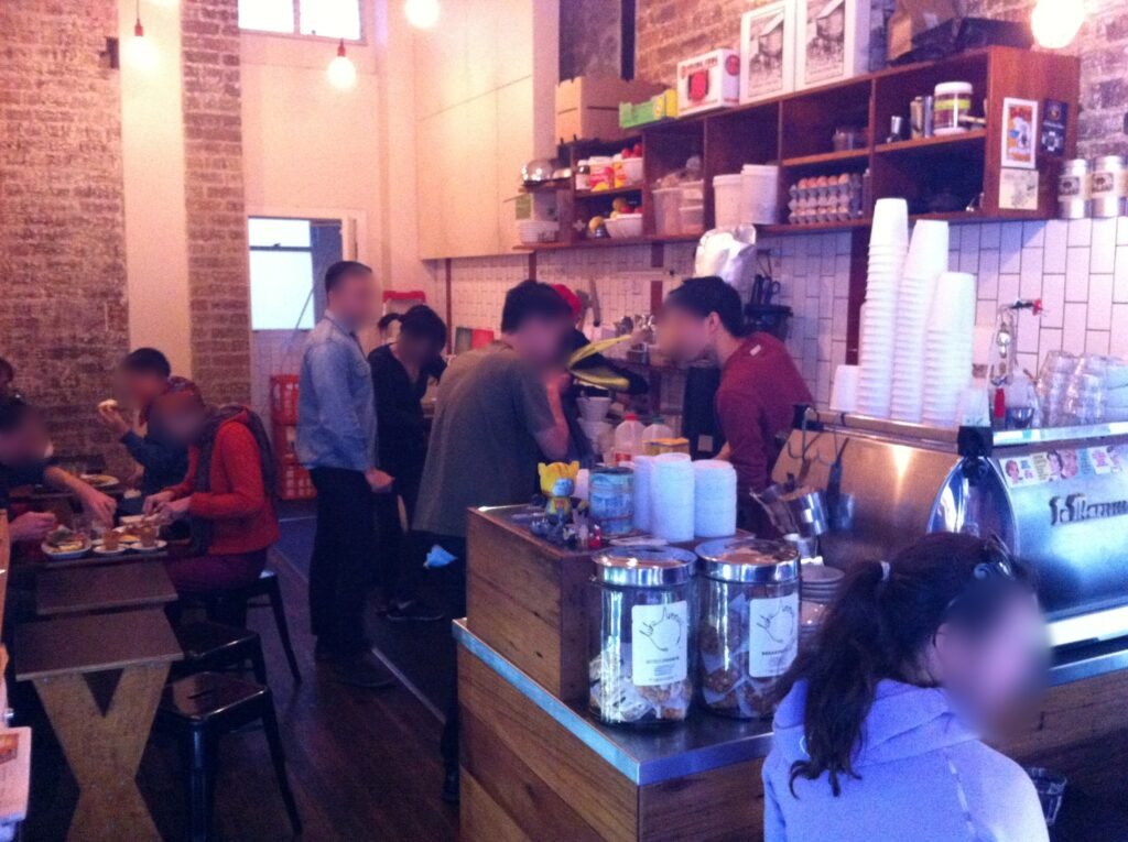 Busy interior of Room 10 with customers eating, several staff working and the espresso machine in the foreground.